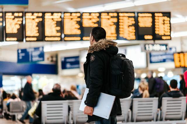 A traveler reads a departures board.